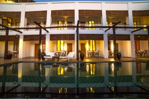 Hotel com piscina, várias varandas e áreas de estar ao ar livre.