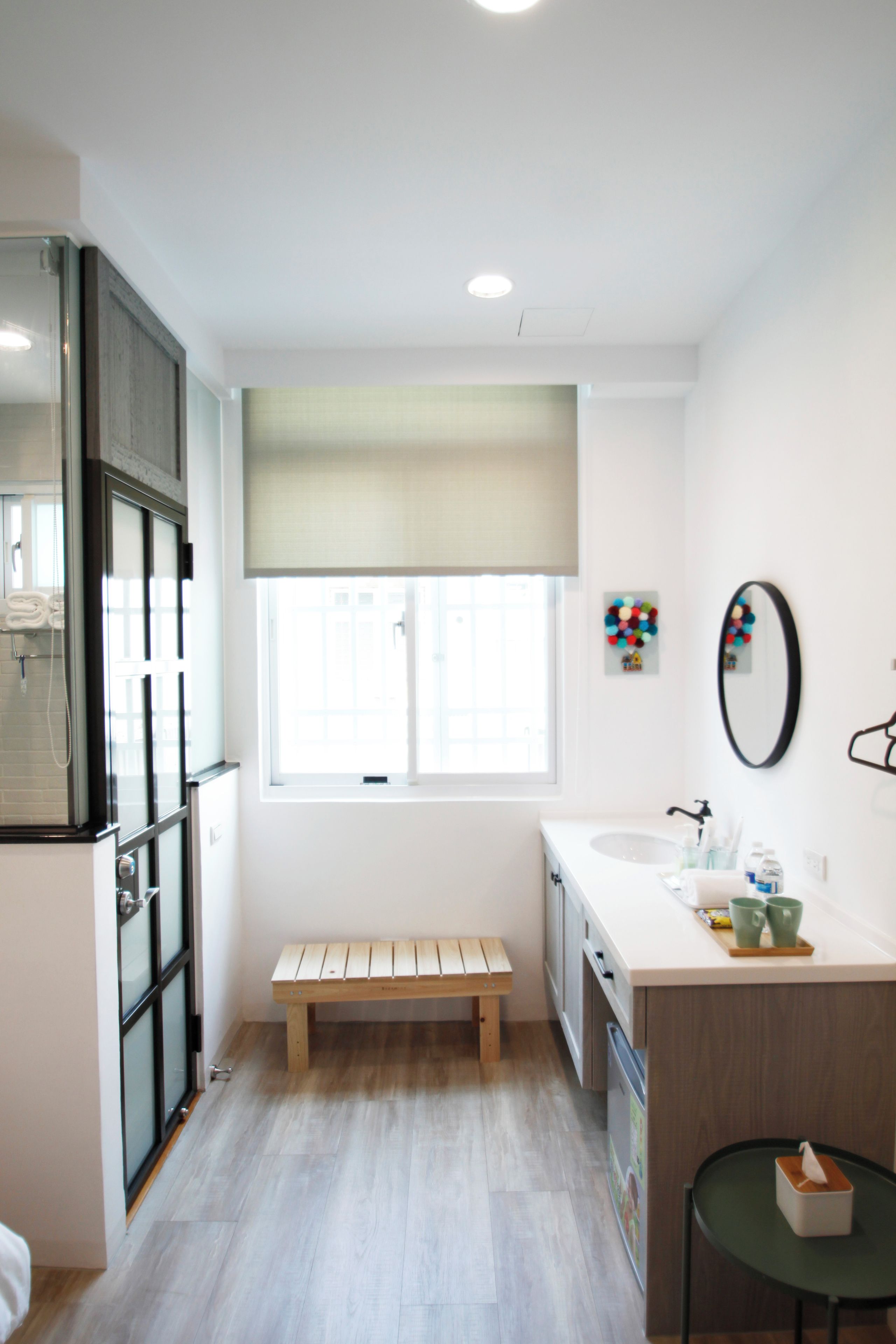 A modern bathroom with a bench, a sink, and a mirror.