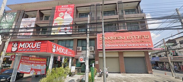 A commercial building with multiple storefronts, including a Mixue ice cream and tea shop and a 7-Eleven convenience store.