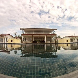 A swimming pool with a building in the background. - K Resort Ngwe Saung Beach (Ngwe Saung)