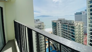 Ein Hochhaus mit einem Balkon mit Blick auf eine Stadtlandschaft und ein Gewässer.