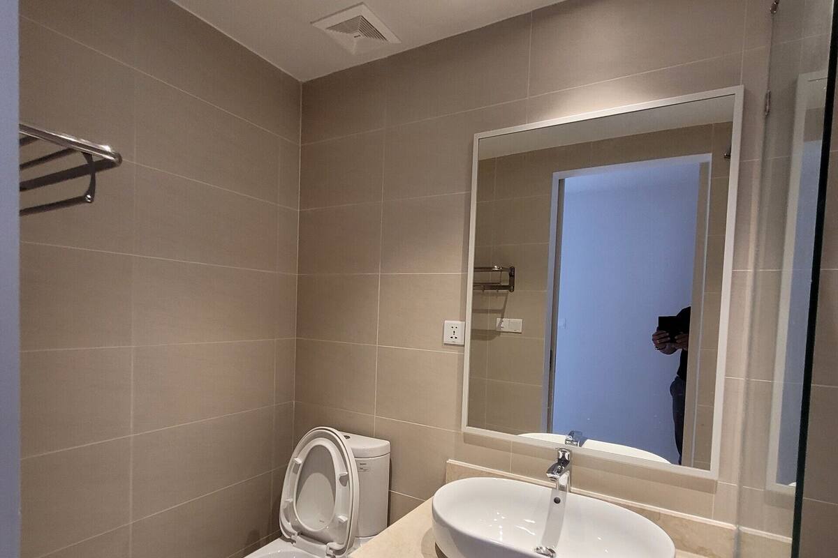 Un baño moderno con inodoro, lavamanos y espejo.