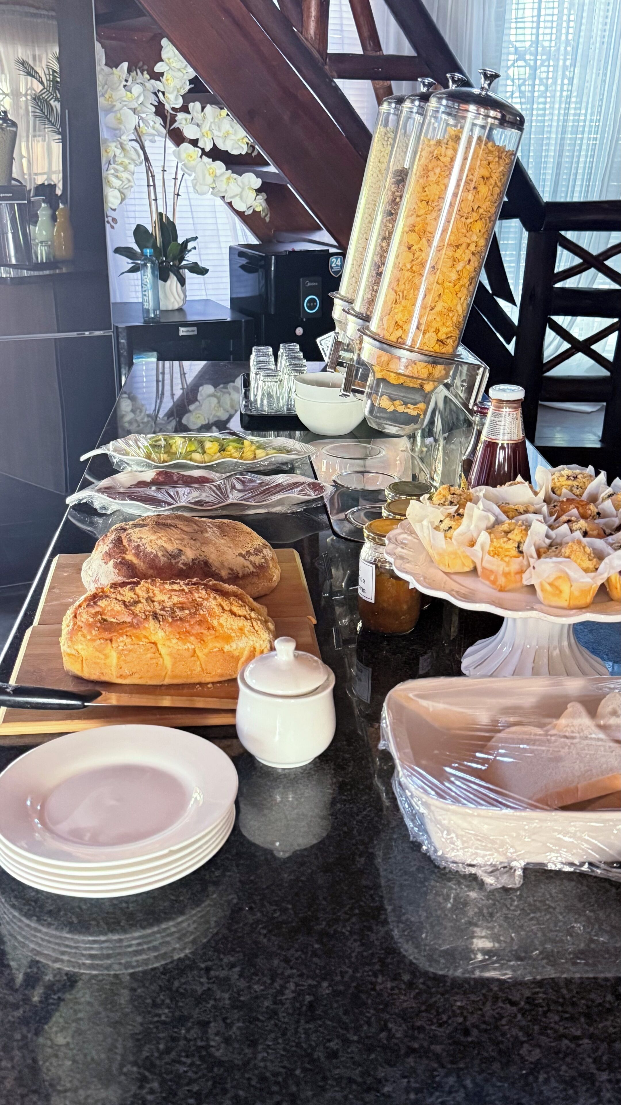 En morgenmadsbuffet med forskellige retter, herunder brød, kager og müslis.