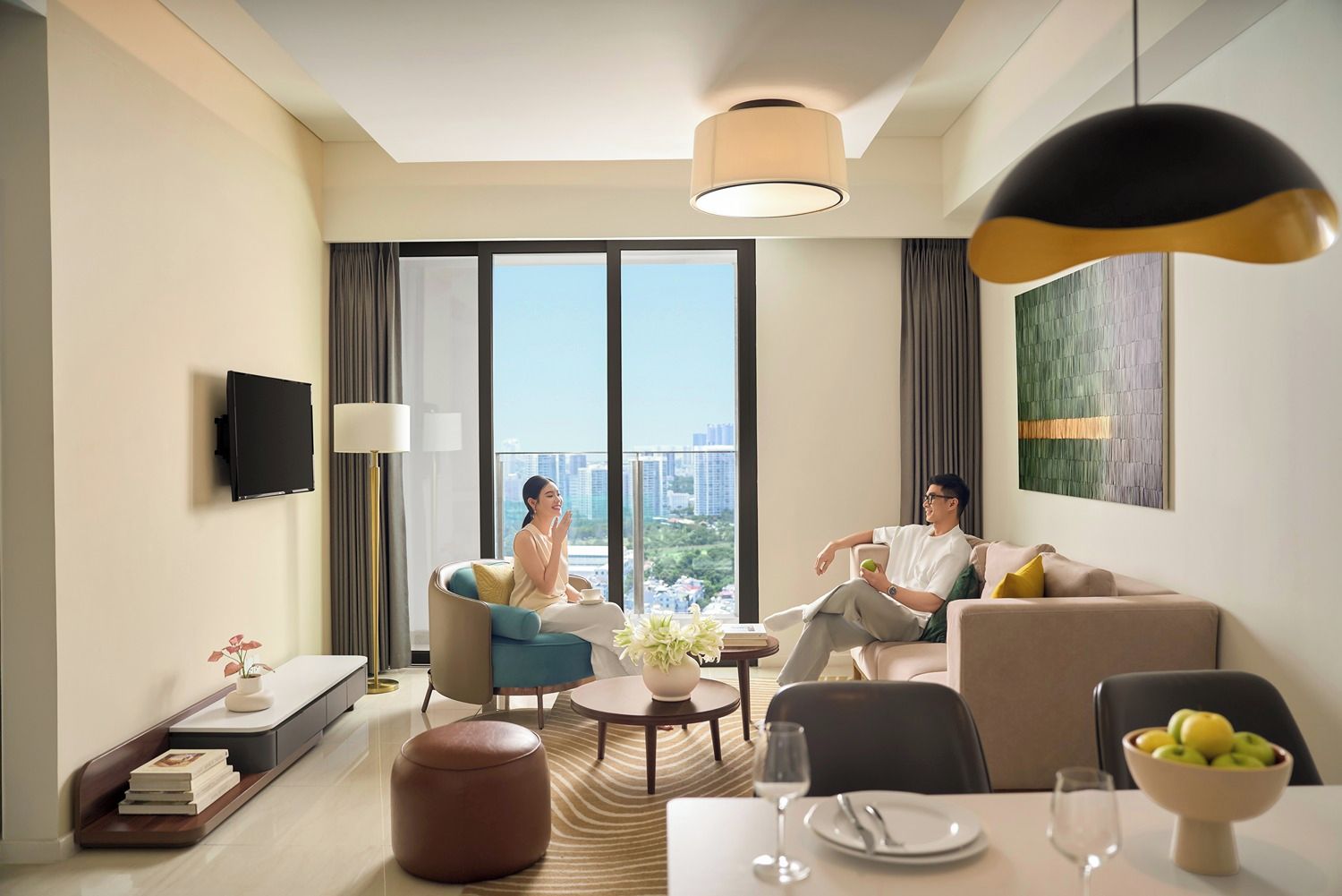 A modern living room with a sofa, a coffee table, and a dining table set for two.
