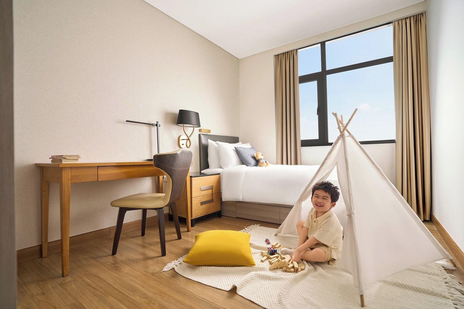 Una habitación de hotel con una cama, un escritorio, una silla, una lámpara, una ventana y una tienda de campaña.