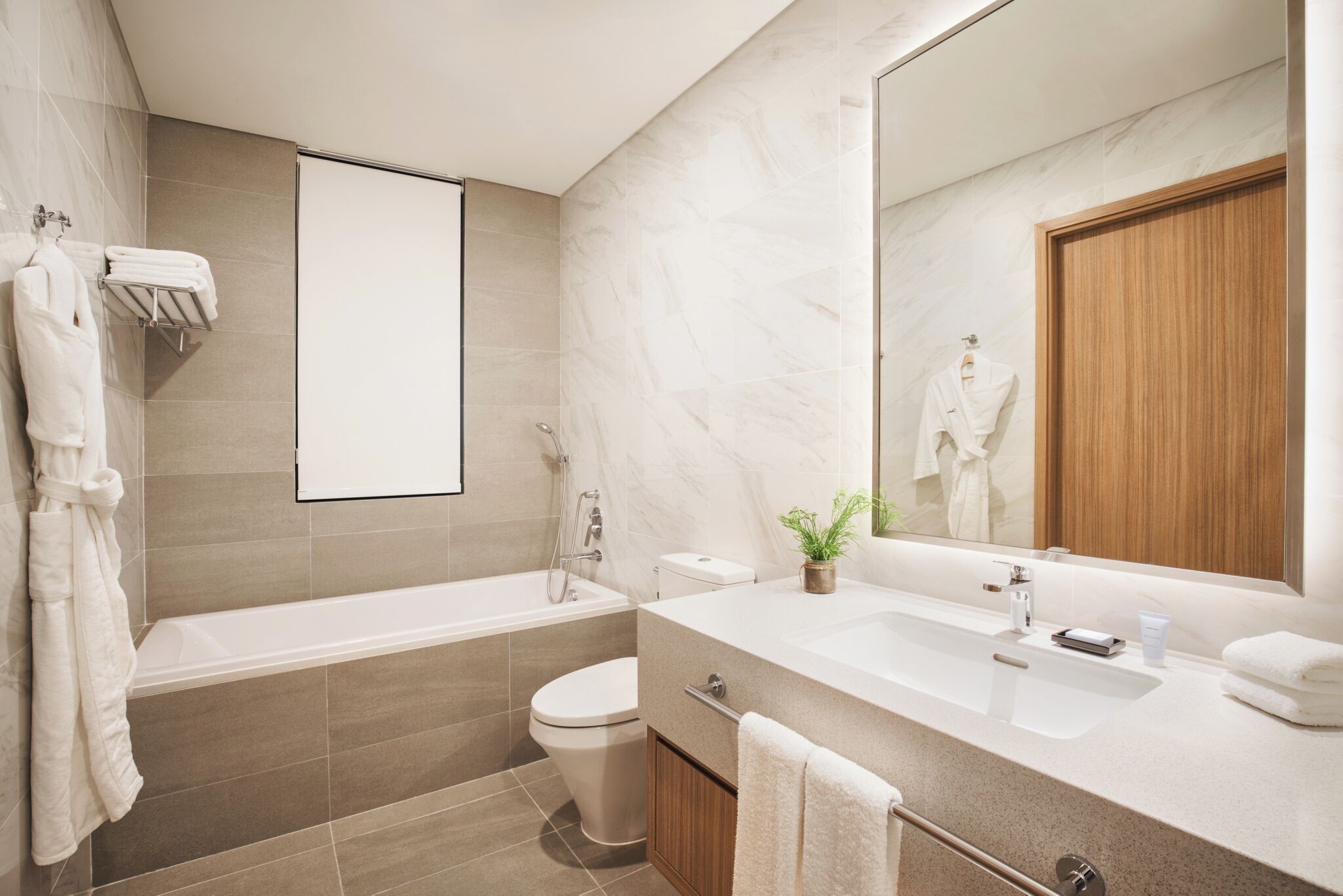 A modern bathroom with a bathtub, toilet, and sink.