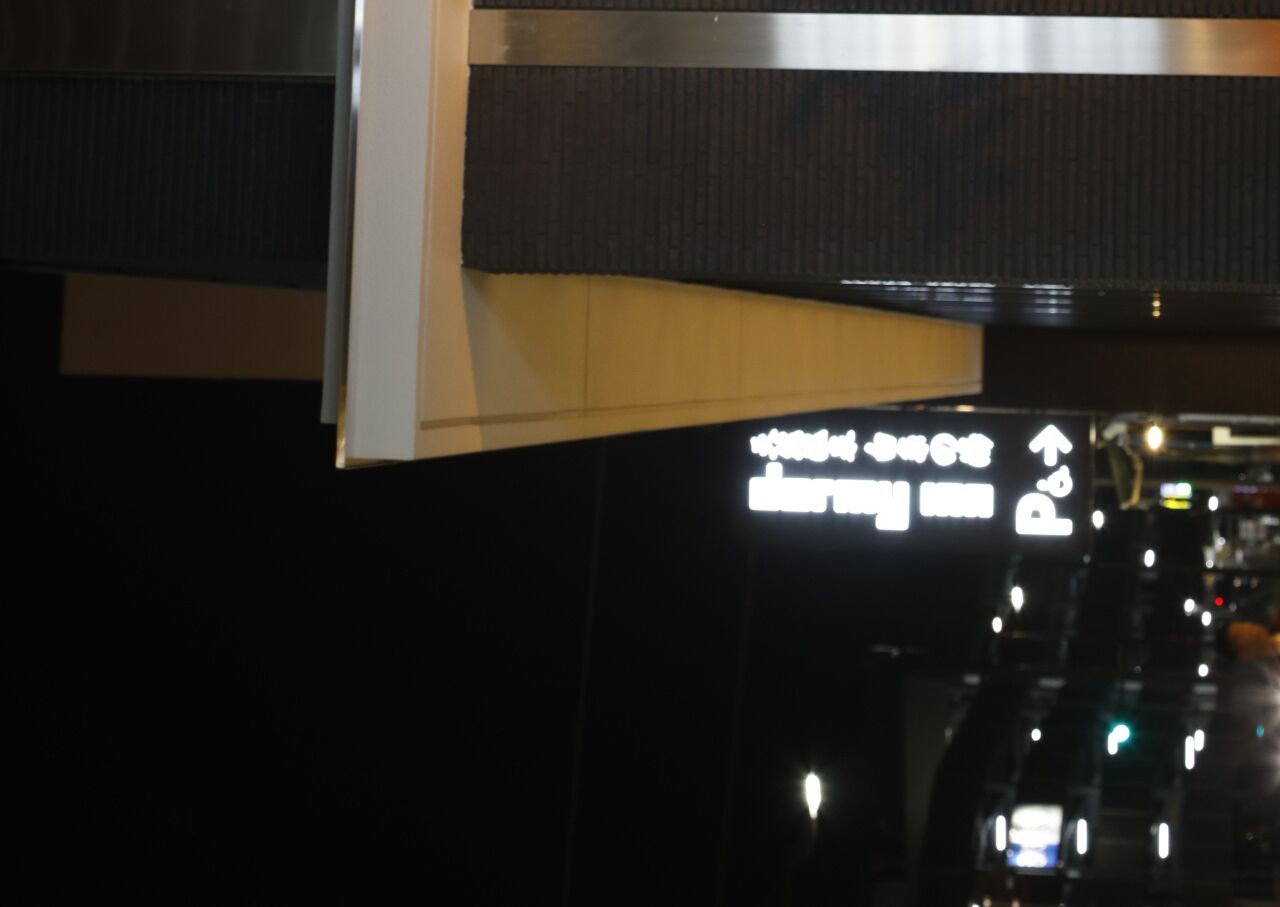 A sign with directional arrows and text, likely indicating hotel or facility directions.