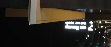 A sign with directional arrows and text, likely indicating hotel or facility directions.