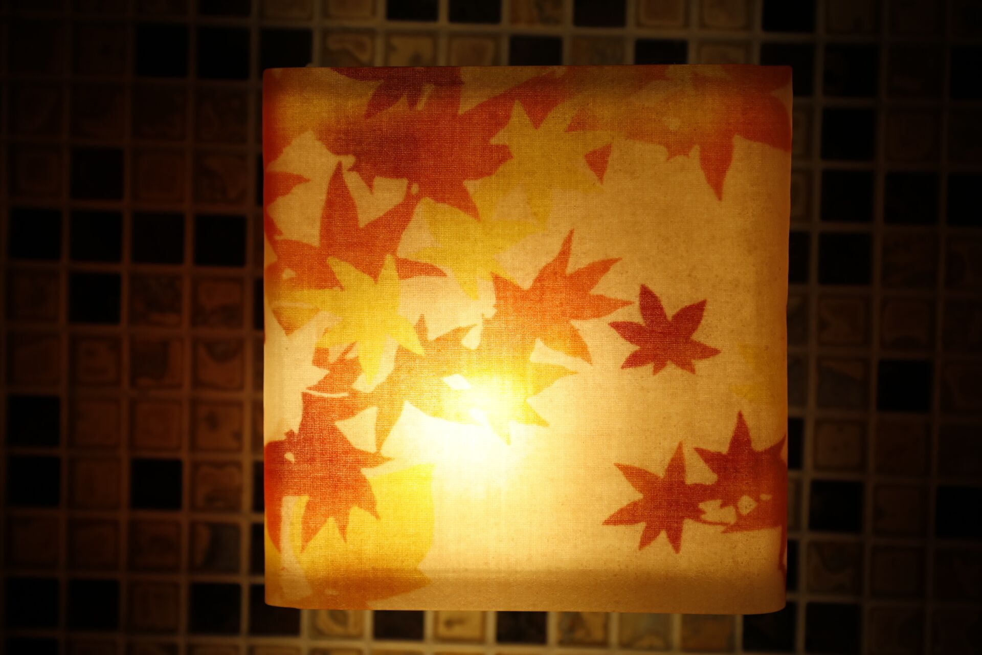 Un objet de forme carrée orné d’un motif de feuilles d’érable rouges.
