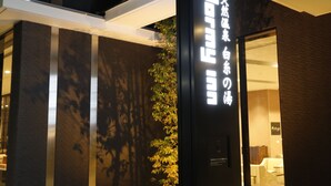 Une façade d’immeuble ornée d’une grande enseigne verticale affichant du texte en japonais.