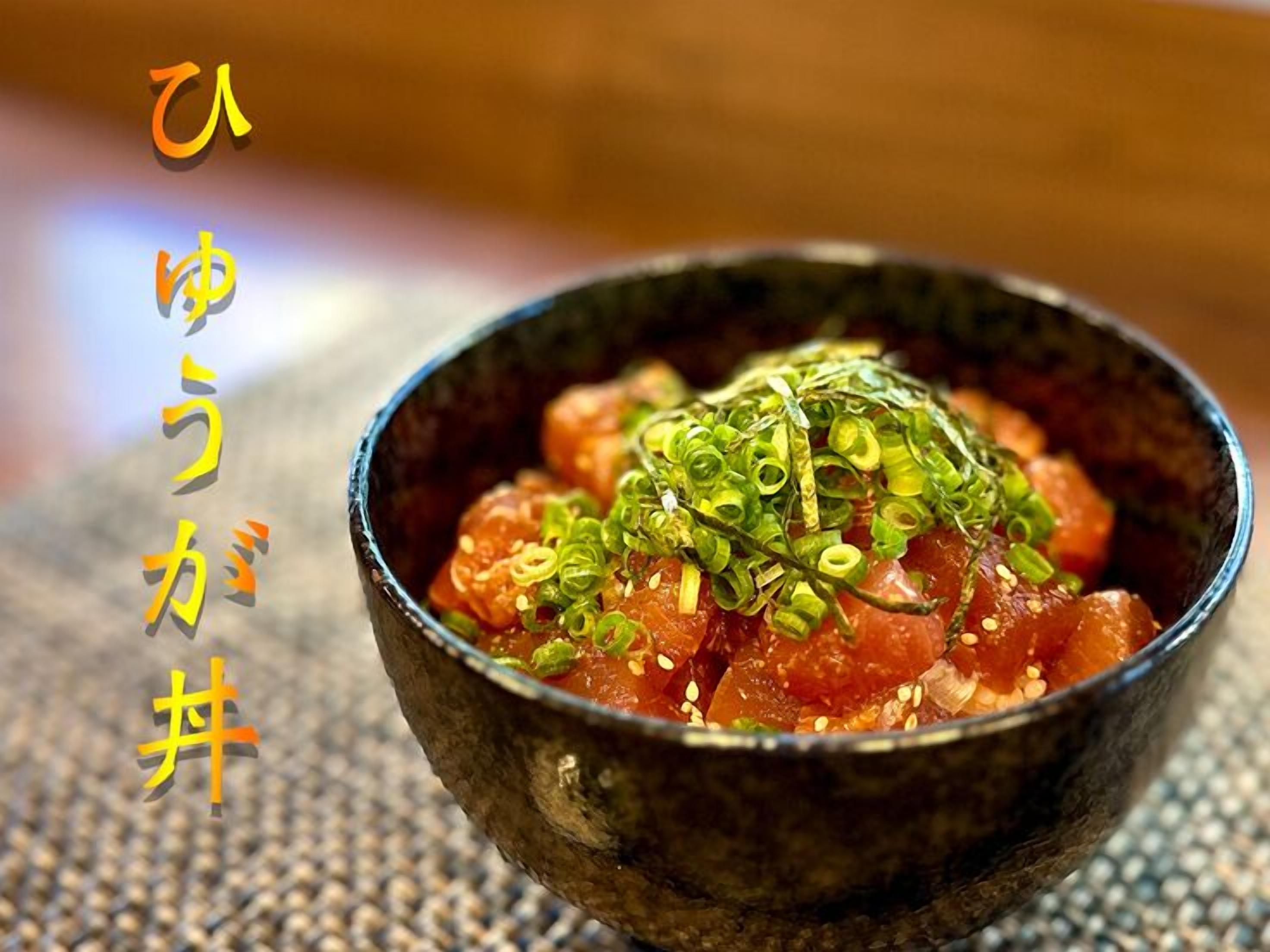 A bowl of sashimi topped with green onions and sesame seeds.