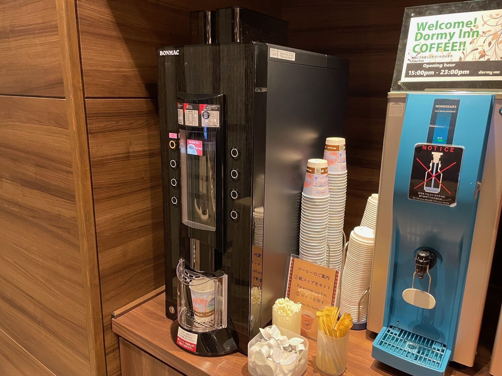 A coffee station with a coffee machine, cups, and a sign welcoming visitors to the coffee area.