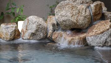 A small waterfall feature with multiple rocks and a stream of water flowing over them.