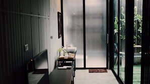 A modern bathroom with a large mirror, a sink, and a bench.