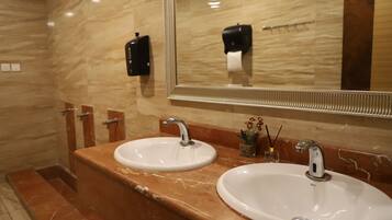 A bathroom with two sinks, marble countertops, and a large mirror.