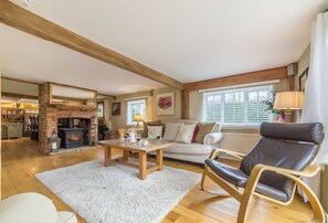 A cozy living room with a fireplace, a sofa, a leather chair, and a dining table. - Cherry Cottage Ripe, nr Lewes , Sussex (nr Lewes)
