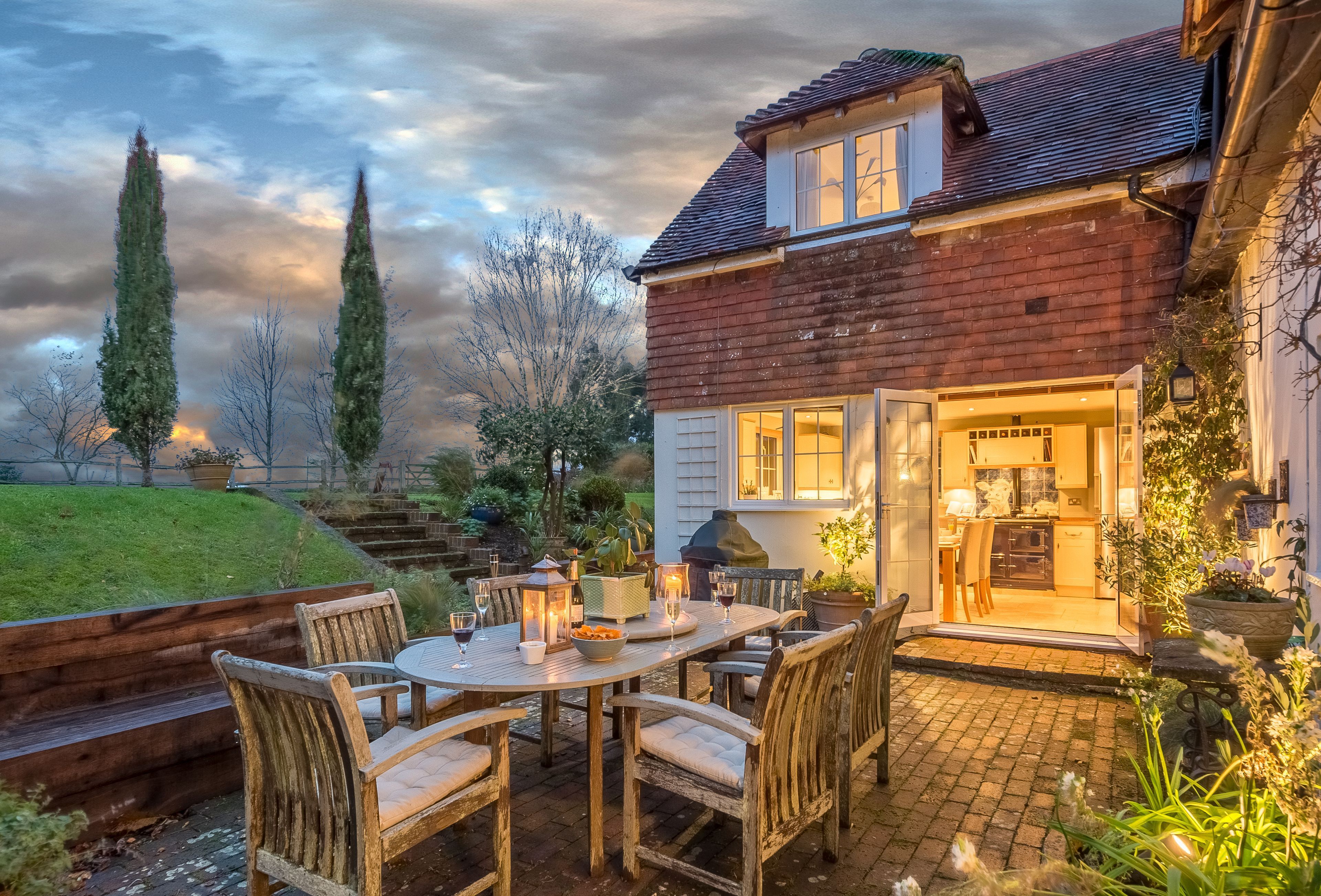 A patio with a table and chairs, a barbecue grill, and a view of the house's interior.