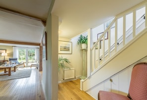A staircase with a handrail and a potted plant on the landing.
