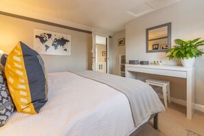 A bedroom with a bed, a desk, a potted plant, and a world map on the wall. - Cherry Cottage Ripe, nr Lewes , Sussex (nr Lewes)