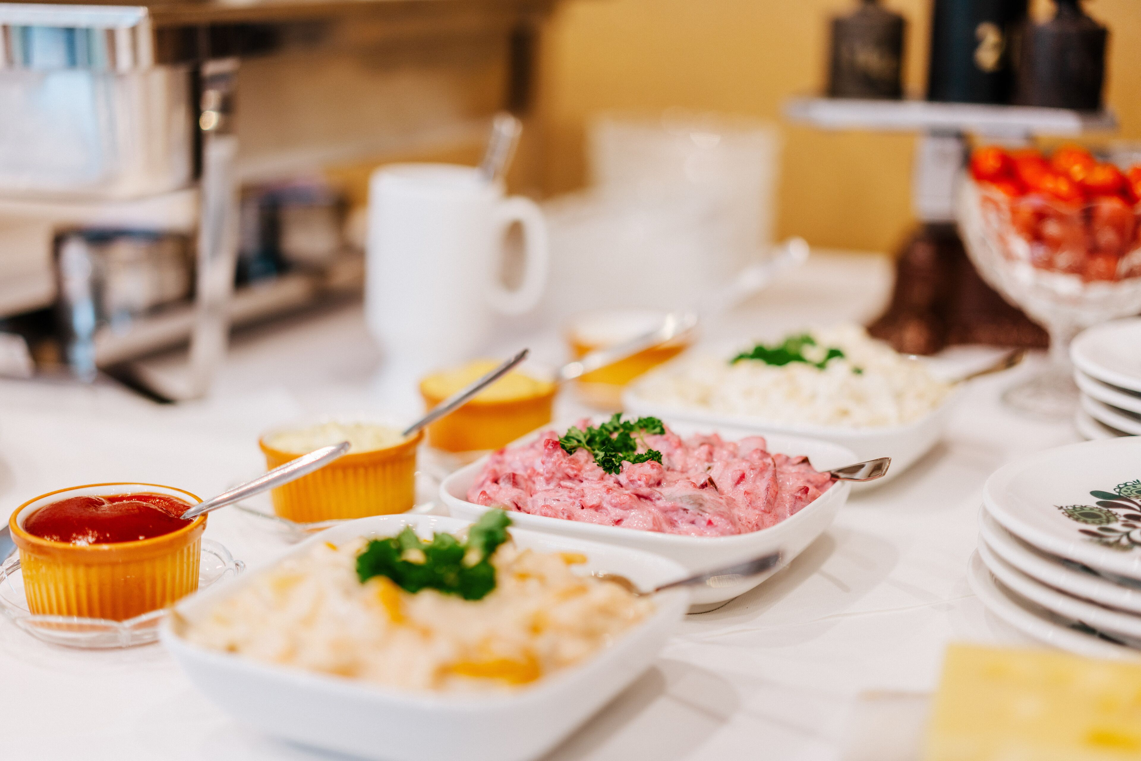 A buffet table with various food items and utensils.