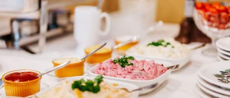 Una mesa de buffet con diferentes tipos de comida y utensilios.