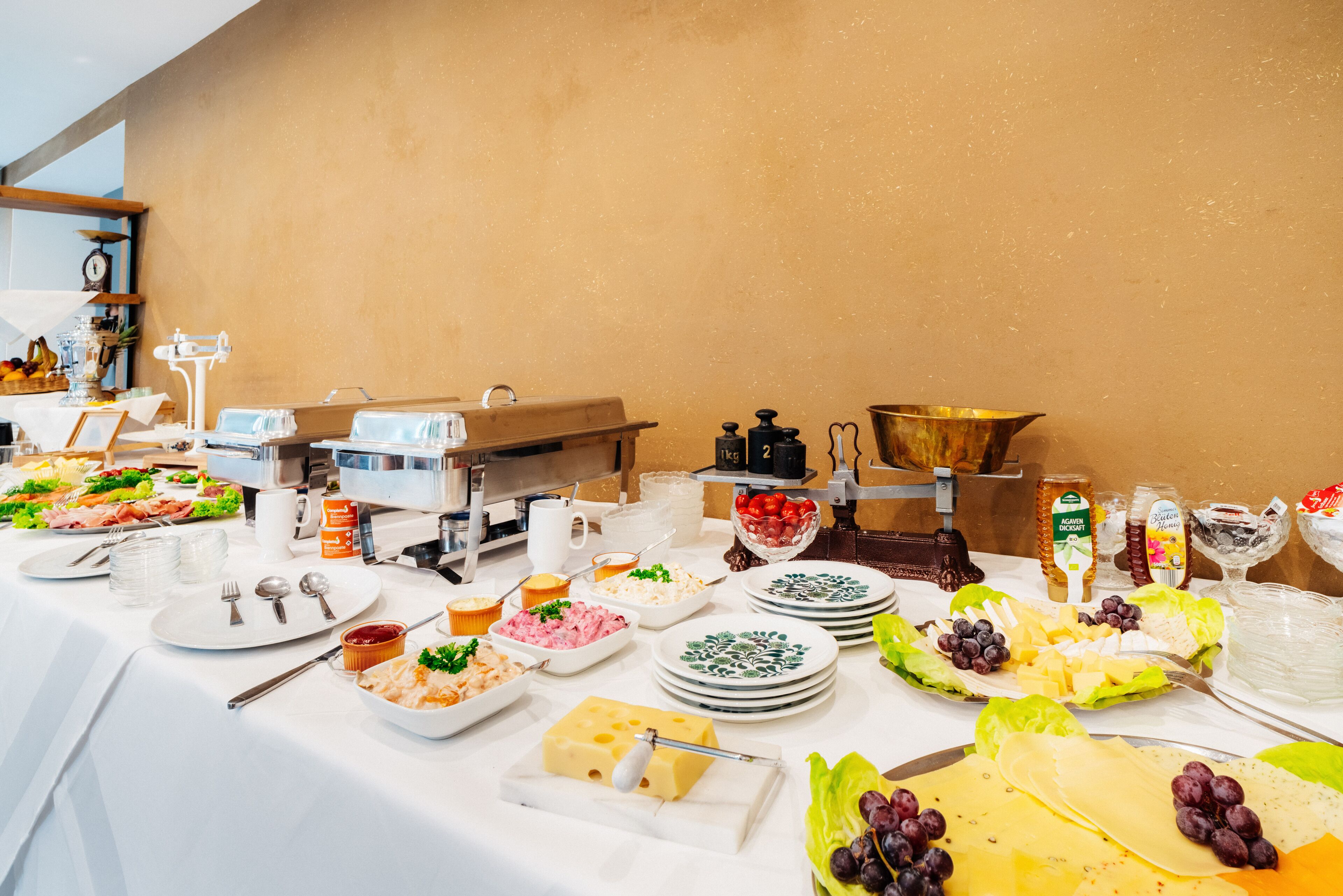 A buffet table with various food items and utensils.