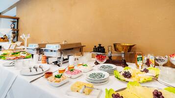 A buffet table with various food items and utensils.