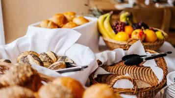 Une variété de pains et de fruits sont disposés sur une table.