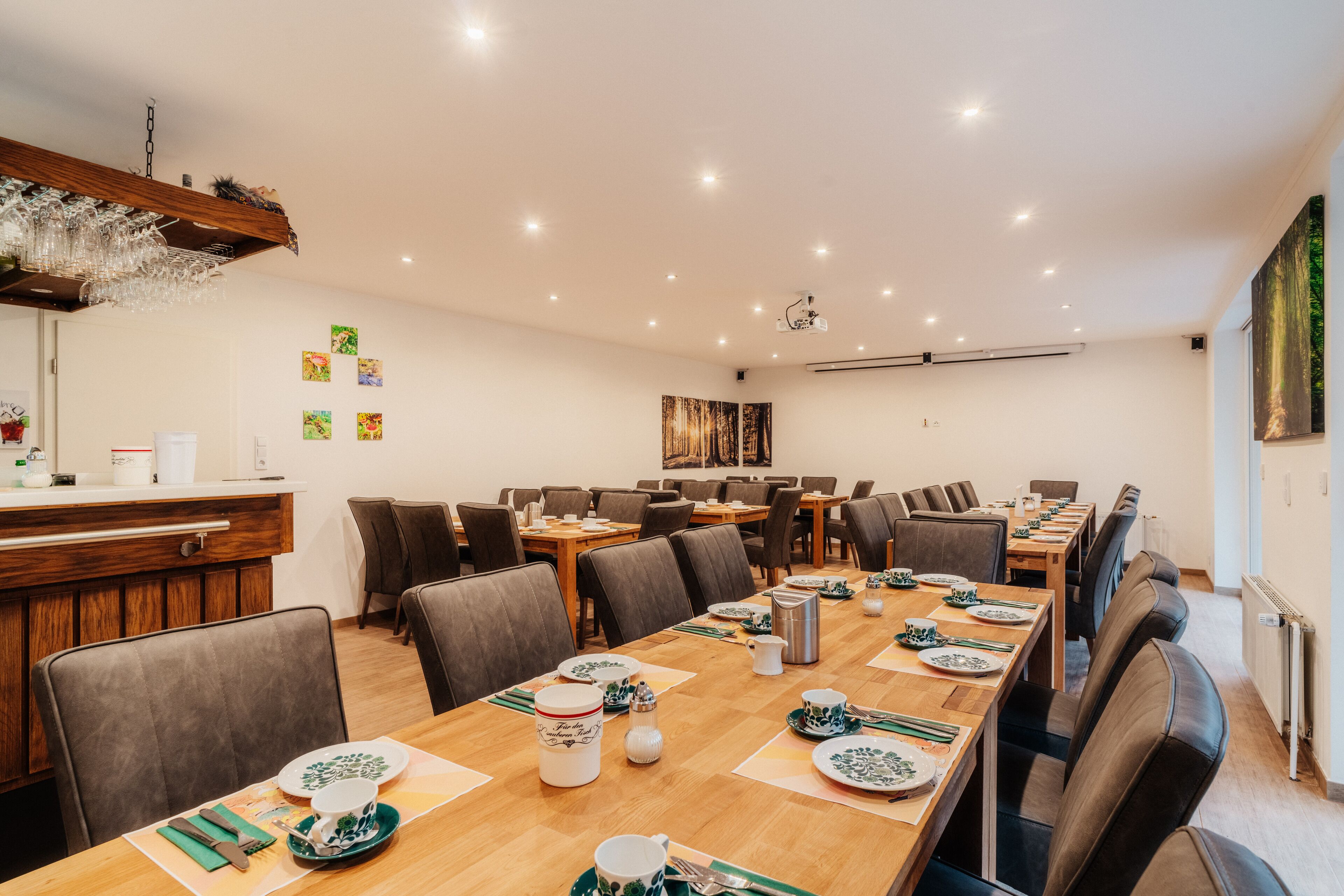 A dining area with multiple tables set for meals, equipped with plates, cutlery, and glassware.