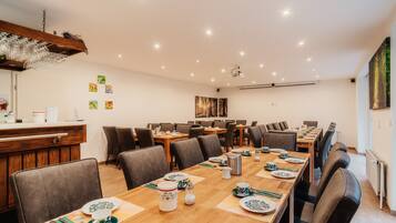 A dining area with multiple tables set for meals, equipped with plates, cutlery, and glassware.