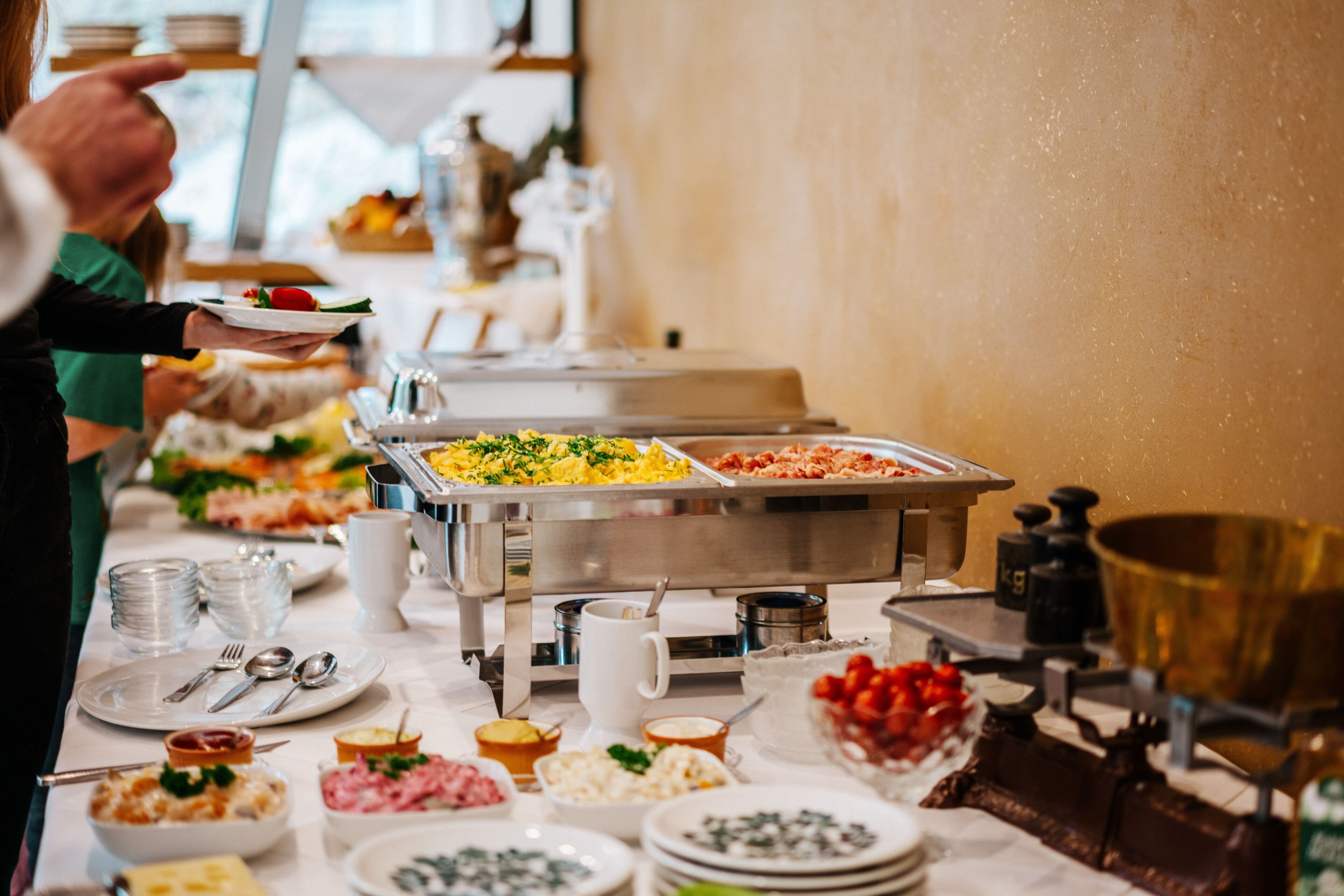 A buffet with various food stations, including a salad bar, a fruit section, and a meat station.