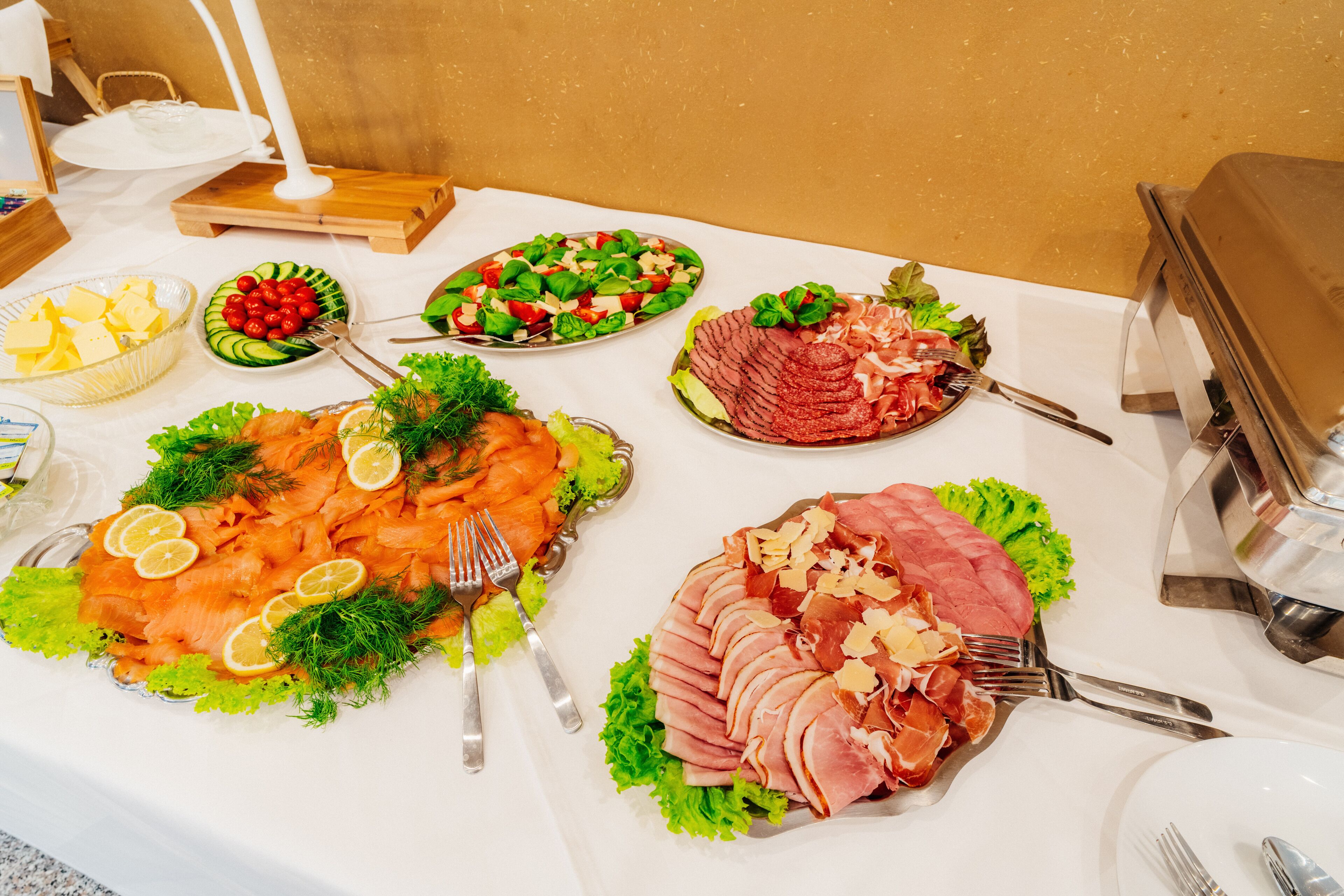 A buffet table with various food items including salmon, ham, and salads.