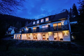 Vista frontal de la propiedad por la tarde o noche