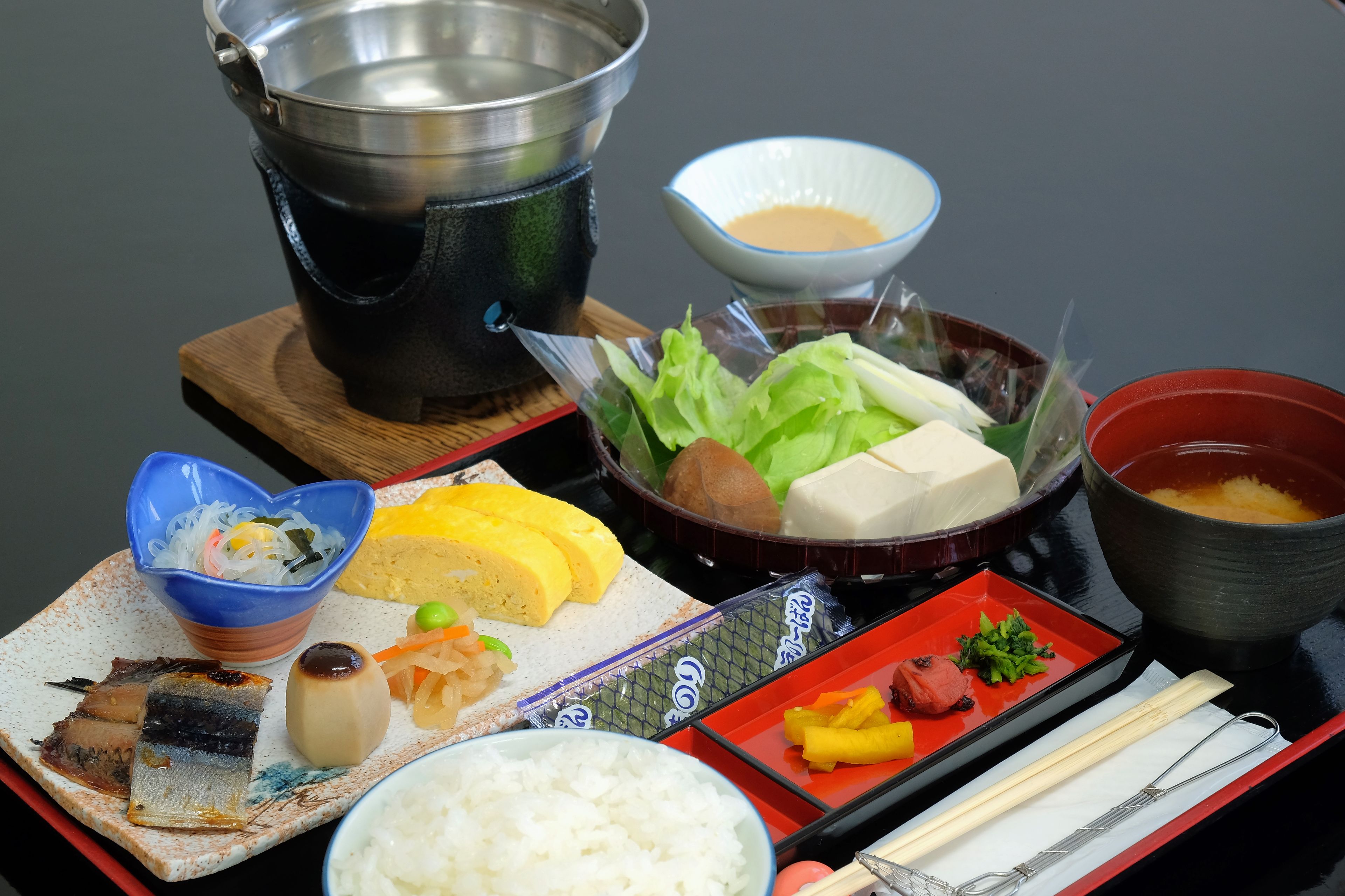 A traditional Japanese meal with various dishes including fish, rice, and vegetables.