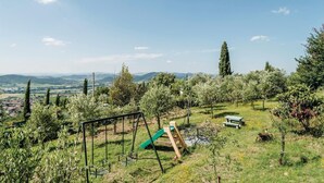 A playground with swings and a slide, surrounded by greenery and a scenic view of distant hills. - Amazing apartment in Magione -PG- with WiFi (Magione -PG-)