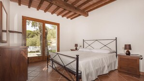 A bedroom with a bed, bedside tables, a dresser, and a sliding glass door leading to an outdoor area. - 2 bedroom cozy home in Scarlino -GR- (Scarlino -GR-)