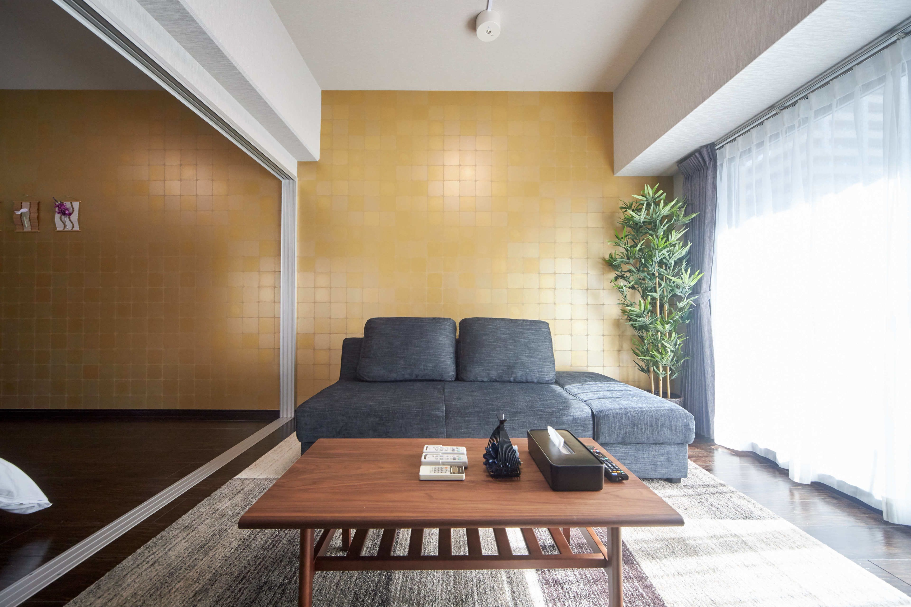 Un salon moderne avec un canapé, une table basse et une plante.