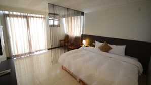 Een hotelkamer met een groot bed, een bureau en een stoel.