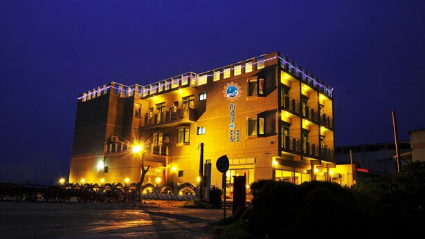 Een meerlaags hotel met verlichte signage en een goed verlichte ingang.