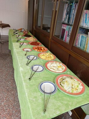 A buffet table with various dishes and utensils.