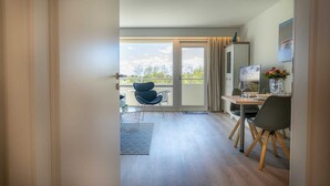 Et moderne hotelværelse med balkon, spiseplads og TV.