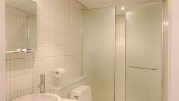A modern bathroom with a white sink, toilet, and shower.