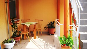 A small outdoor patio with a table and two chairs, surrounded by potted plants. - Friendly People's Guest House (Zadar)
