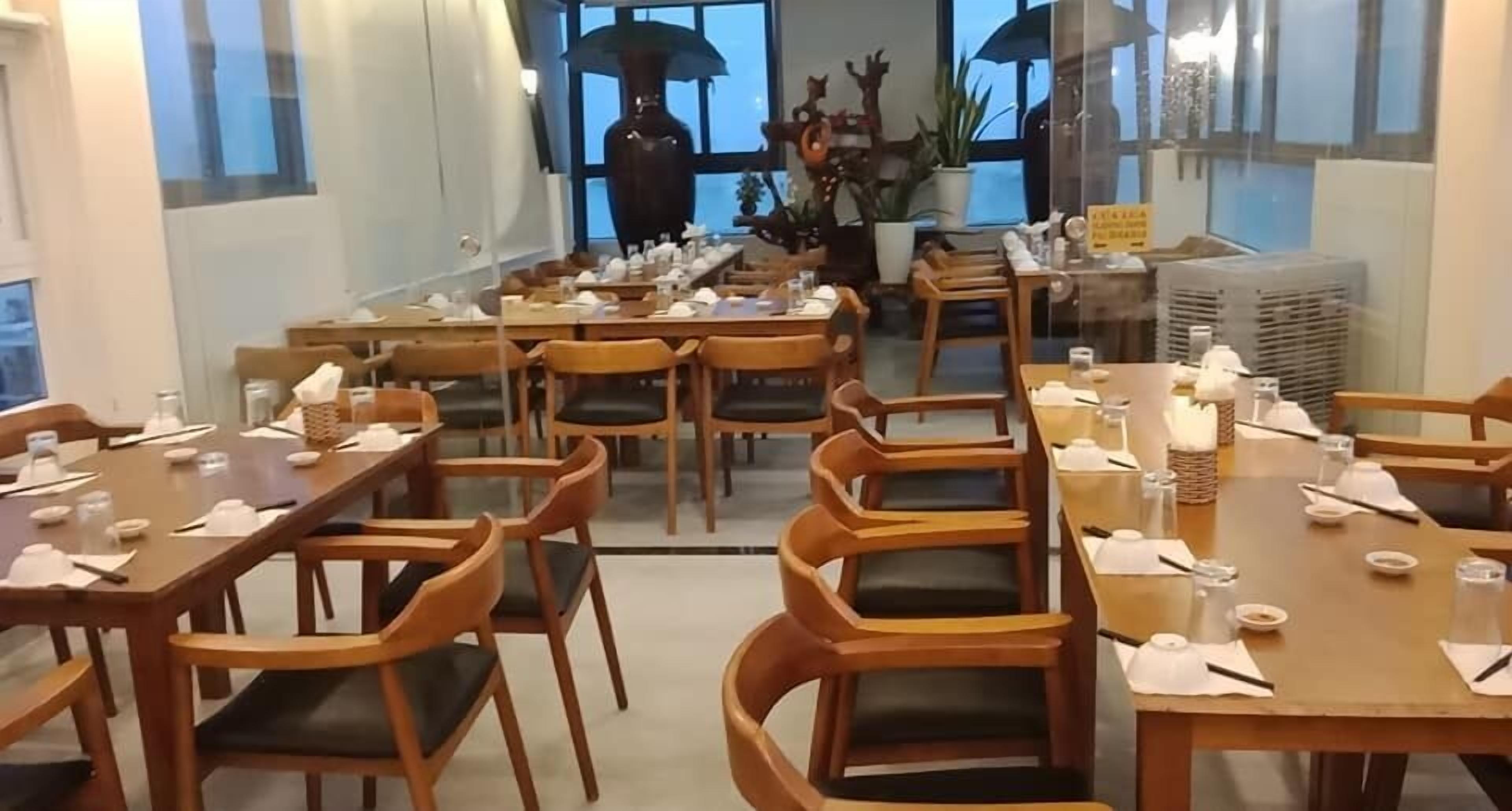 A restaurant with multiple wooden tables and chairs, arranged in a spacious layout.