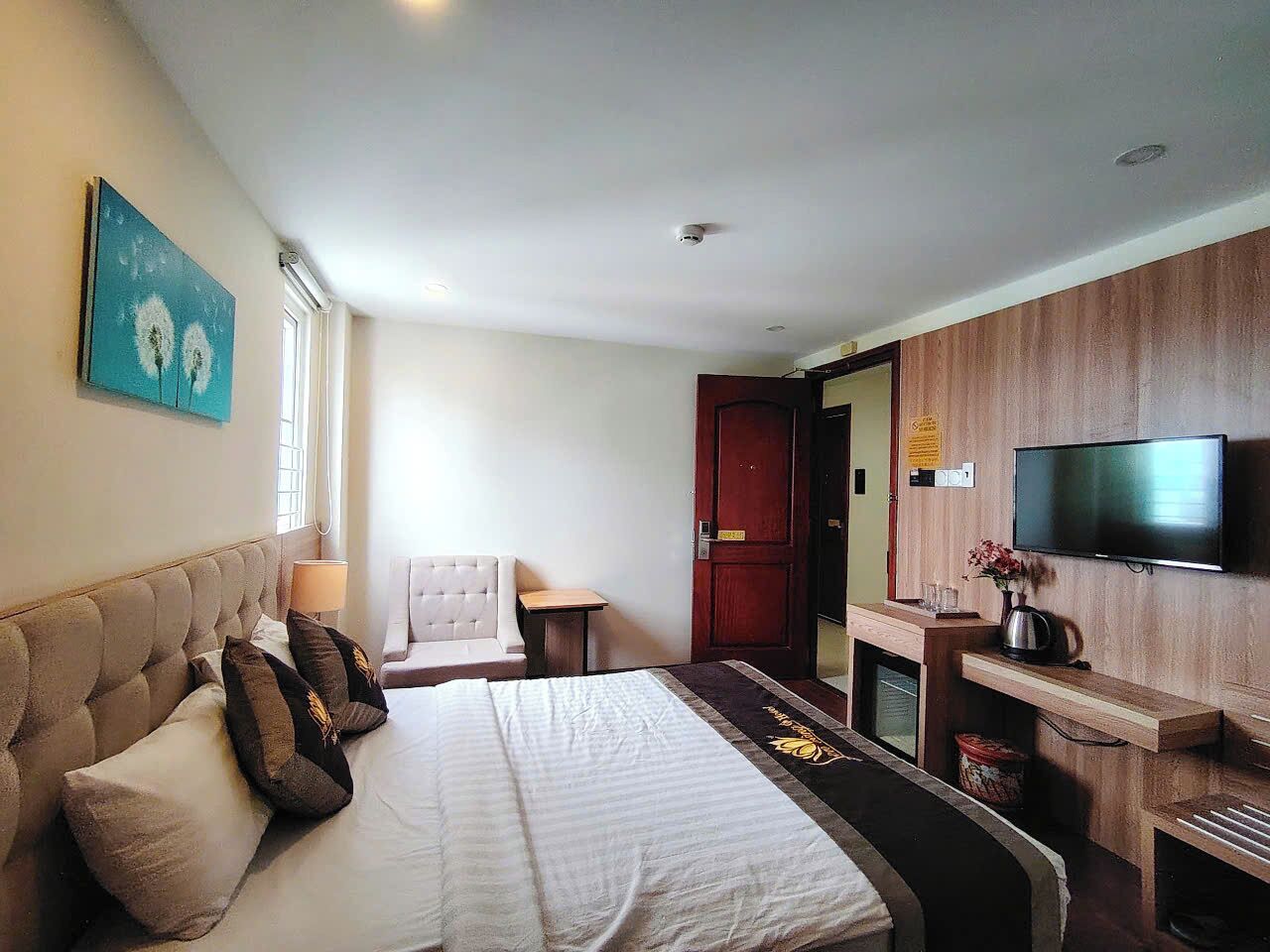 A hotel room with a bed, a television, a desk, and a chair.