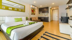 A modern hotel room with a large bed, a small kitchenette, and a separate seating area. - iCheck inn Residence Sukhumvit 1 (Bangkok)