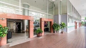 A modern hotel lobby with glass doors, potted plants, and a wooden floor. - iCheck inn Residence Sukhumvit 1 (Bangkok)