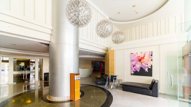 A spacious lobby with a central column, seating area, and a large floral artwork on the wall. - iCheck inn Residence Sukhumvit 1 (Bangkok)
