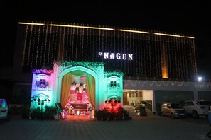 Entrada de hotel con un letrero que dice "SHAGUN" y un arco decorativo.
