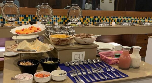 Montaje de bufé con diversas opciones de comida, utensilios y salsas.